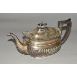 AN EDWARDIAN SILVER TEAPOT OF GEORGIAN STYLE, gadrooned rim, half reeded, ebonised fitments,