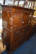 AN EARLY 20TH CENTURY OAK COURT CUPBOARD with two drawers on casters, width 127cm x depth 47cm x