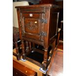 AN EARLY 20TH CENTURY CARVED OAK POT CUPBOARD raised on turned legs united by a stretcher, width