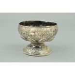 AN INDIAN WHITE METAL PEDESTAL BOWL, embossed decoration of animals, figures, foliage and buildings,