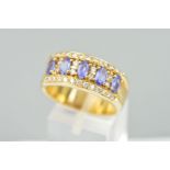A TANZANITE AND DIAMOND RING, designed as five oval tanzanites each interspaced by two brilliant cut