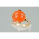 AN ORANGE PASTE RING, the circular orange paste within a four claw setting, stamped 9ct, ring size