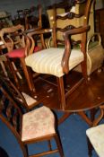 A NEAR SET OF SIX EDWARDIAN MAHOGANY FOLIATE CARVED LADDER BACK CHAIRS, with various upholstered