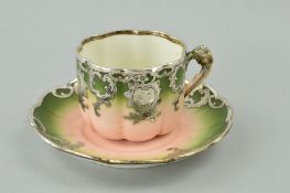 A PORCELAIN CUP AND SAUCER, with white metal mounts