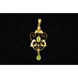 AN EARLY 20TH CENTURY GOLD GEM PENDANT, of openwork scrolling design, centrally set with an oval