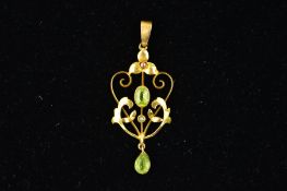AN EARLY 20TH CENTURY GOLD GEM PENDANT, of openwork scrolling design, centrally set with an oval