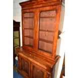 A VICTORIAN FLAME MAHOGANY GLAZED TWO DOOR BOOKCASE above a single long drawer and double cupboard