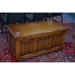 A REPRODUCTION OAK LINENFOLD TRIPLE PANEL BLANKET CHEST, approximate width 107cm x depth 46cm x