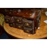 A CARVED OAK CONTINENTAL MINIATURE CHEST OF FOUR VARIOUS DRAWERS, made up of older timbers, the door