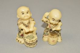 TWO RESIN NETSUKES, moulded as a boy drumming and a boy with a bucket, maximum height 4.5cm (2)