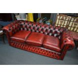 AN OX BLOOD LEATHER THREE SEATER CHESTERFIELD SETTEE, approximate width 192cm