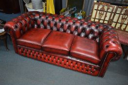 AN OX BLOOD LEATHER THREE SEATER CHESTERFIELD SETTEE, approximate width 192cm