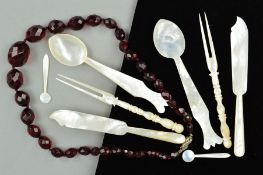 A FACETED RED PLASTIC BEAD NECKLACE AND MOTHER OF PEARL CUTLERY, the necklace comprising of