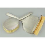 A THREE PIECE SILVER BACKED DRESSING TABLE SET, comprising hand mirror (loose) and two brushes,