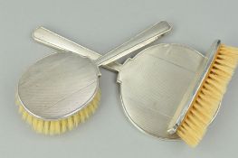 A THREE PIECE SILVER BACKED DRESSING TABLE SET, comprising hand mirror (loose) and two brushes,