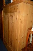 A LARGE PINE TWO DOOR WARDROBE above two drawers, approximate width 145cm x depth 56cm x height