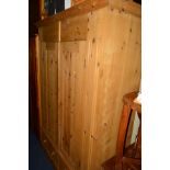 A LARGE PINE TWO DOOR WARDROBE above two drawers, approximate width 145cm x depth 56cm x height