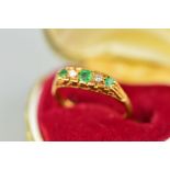 AN 18CT GOLD EMERALD AND DIAMOND RING, designed as three graduated circular emeralds interspaced