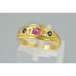 AN EARLY 20TH CENTURY 18CT GOLD RUBY, SAPPHIRE AND DIAMOND RING, designed as a central circular ruby