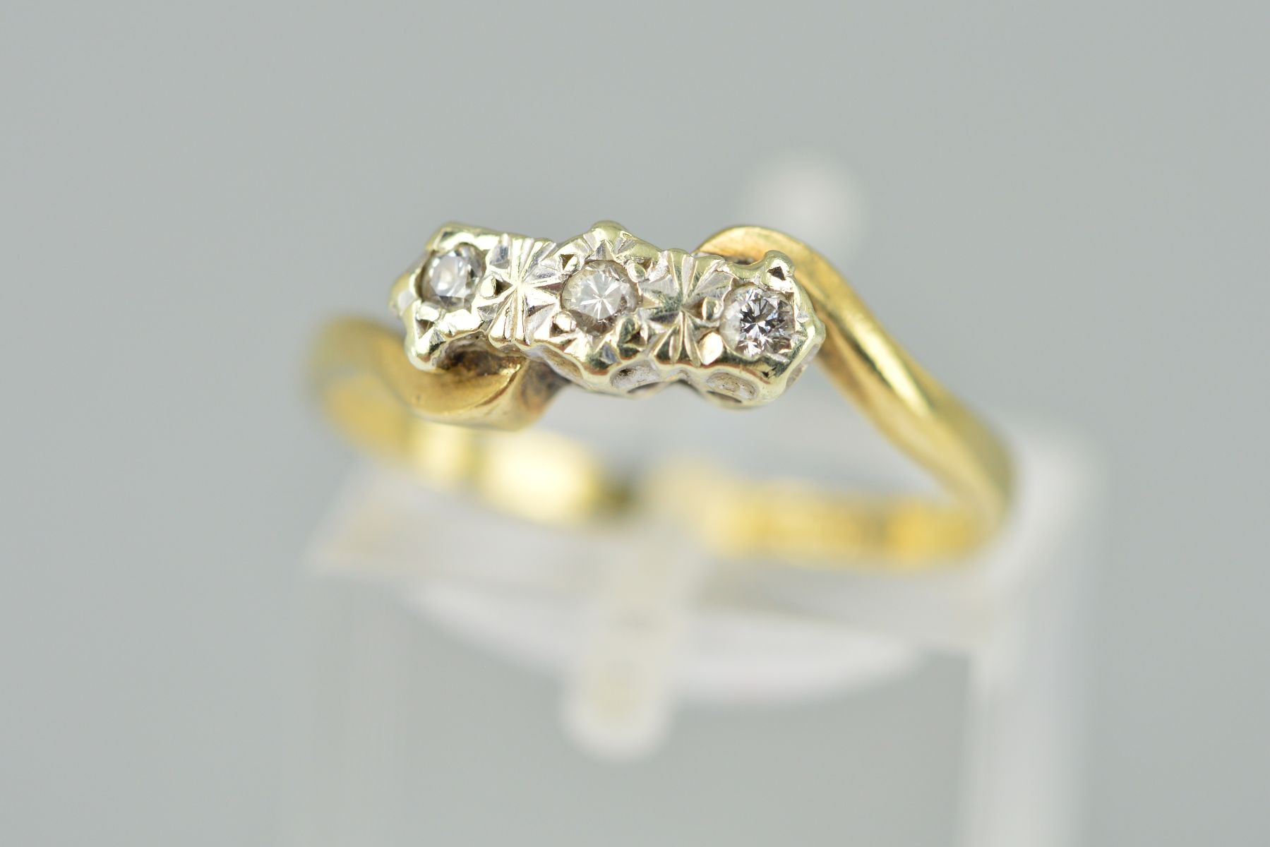 A 9CT GOLD THREE STONE DIAMOND RING, the three brilliant cut diamonds with illusion settings to