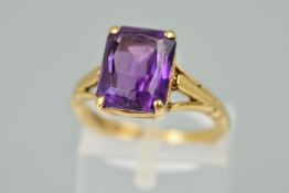 A 9CT GOLD AMETHYST RING, the rectangular amethyst within a four claw setting to the branched