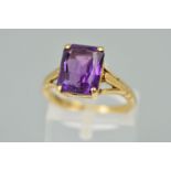 A 9CT GOLD AMETHYST RING, the rectangular amethyst within a four claw setting to the branched