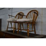 A PAIR OF BLONDE ERCOL BEECH STICK BACK ARMCHAIRS (sd) together with a teak tile topped nest of