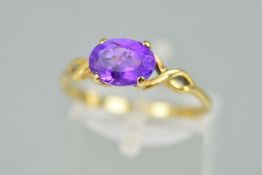 A 9CT GOLD AMETHYST RING, designed as an oval amethyst within a four claw setting to the open