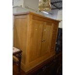 A LIGHT OAK SIDEBOARD flanked by three deep drawers and double cupboard doors, width 97cm x depth