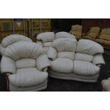 A FOUR PIECE CREAM LEATHER LOUNGE SUITE comprising of a pair of two seater settee and two chairs (