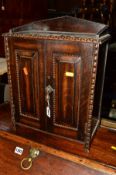 AN EARLY 20TH CENTURY OAK TWO DOOR SMOKERS CABINET revealing two drawers and a seperate ash tray