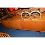 A 1970'S TEAK SIDEBOARD with three various drawers and three cupboard doors on four tapering