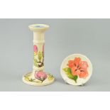 TWO PIECES OF MOORCROFT POTTERY, to include candlestick, 'Magnolia' pattern on cream ground,