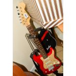 A 'SQUIER MINI' ELECTRIC GUITAR BY FENDER, in red and cream with soft hold-all