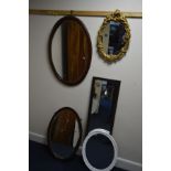 AN EDWARDIAN OVAL MAHOGANY BEVELLED EDGE WALL MIRROR, another similar wall mirror, gilt framed