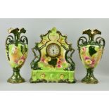 A CERAMIC CLOCK GARNITURE, florally decorated on green ground with gilt overlay, one hand loose on