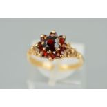 A 9CT GOLD GARNET CLUSTER RING, the central circular garnet within a tiered circular garnet surround