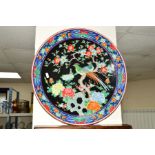 A JAPANESE CERAMIC CHARGER, the central panel decorated with a pair of exotic birds perched in a