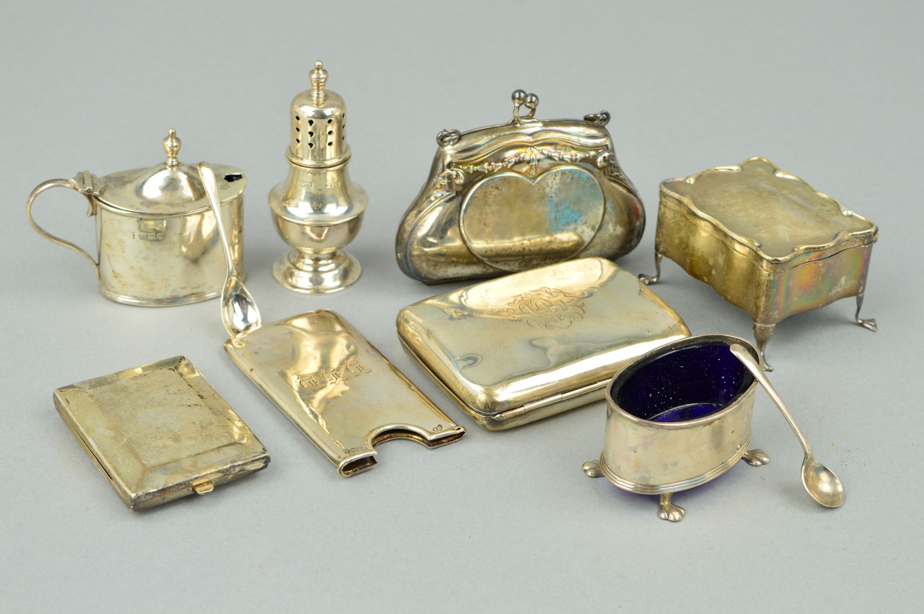 A GROUP OF SILVER COMPRISING A SILVER PURSE, a three piece condiment set and two spoons, a cigarette