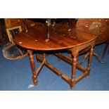 A REPRODUCTION OVAL TOPPED DROP LEAF TABLE