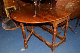 A REPRODUCTION OVAL TOPPED DROP LEAF TABLE