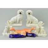 A PAIR OF VICTORIAN STAFFORDSHIRE POTTERY FIGURES OF SEATED DOGS, modelled with fences behind, on