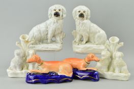 A PAIR OF VICTORIAN STAFFORDSHIRE POTTERY FIGURES OF SEATED DOGS, modelled with fences behind, on