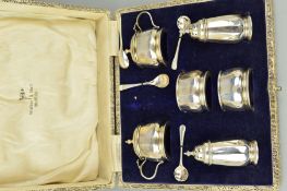 A CASED GEORGE V SIX PIECE SILVER CRUET SET, of panelled form, comprising pair of pepperettes,