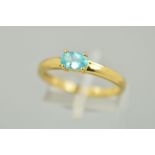 A 9CT GOLD GEM RING, the oval shape gem assessed as apatite within a four claw setting to a plain