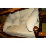 AN OAK FRAMED CREAM UPHOLSTERED TWO SEATER SETTEE