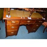 AN EDWARDIAN MAHOGANY KNEE HOLE DESK with a dark green tooled leather inlay top and seven various