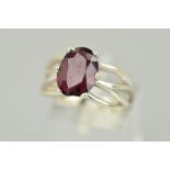 A 9CT WHITE GOLD GARNET RING, the oval garnet within a six claw setting to the openwork shoulders,