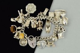 A SILVER CHARM BRACELET, the curb link charm bracelet suspending 26 charms to include a hinged