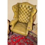 A 20TH CENTURY OLIVE GREEN BUTTONED WING BACK ARMCHAIR (worn but no splits)